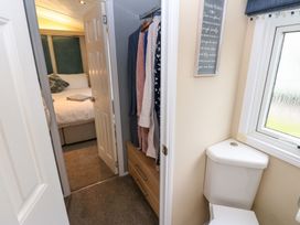 A bathroom with a toilet and a view of a bedroom at A and C Lodge-Plot 21 Armathwaite