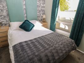 A bedroom with a bed and bedside table at A and C Lodge-Plot 21 Armathwaite