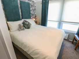 A bedroom with a bed and teddy bear at A and C Lodge-Plot 21 Armathwaite