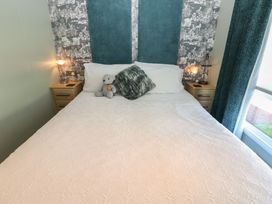 A bedroom with a bed and nightstands at A and C Lodge-Plot 21 Armathwaite