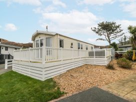 A mobile home with a deck and gravel area at Seaviews in Nefyn