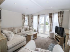 A living room with a sofa and television at Seaviews in Nefyn
