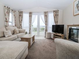 A living room with a sofa and television at Seaviews in Nefyn