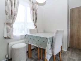 A dining room with a table and chairs at Seaviews in Nefyn
