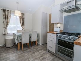 A kitchen with a dining table and stove at Seaviews in Nefyn