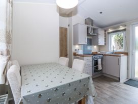 A kitchen with dining table and chairs at Seaviews in Nefyn
