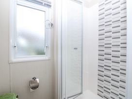 A bathroom with shower and window at Seaviews in Nefyn