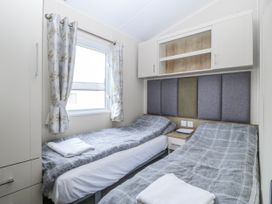 A bedroom with twin beds and a window at Seaviews Nefyn