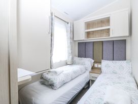 A bedroom with two beds and a wardrobe at Seaviews in Nefyn