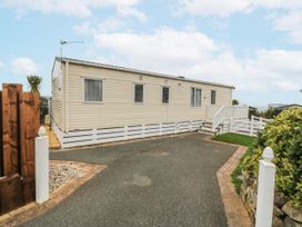 A caravan with steps and fence at Seaviews in Nefyn