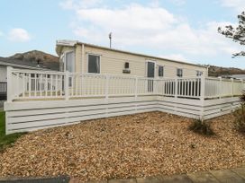 A caravan with decking and gravel outside at Seaviews Nefyn