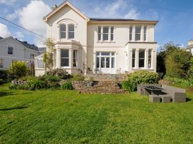 A large house with multiple windows and a garden with patio furniture at Duncombe in Teignmouth