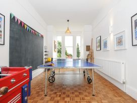 A game room with a ping pong table and foosball table and wall art at Duncombe in Teignmouth