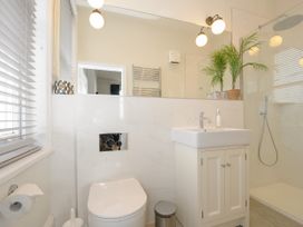 A bathroom with a toilet sink cabinet shower and window blinds at Duncombe in Teignmouth