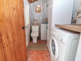 A small utility room with a washing machine toilet and sink at Yr Angor The Anchor in Llandudno Junction