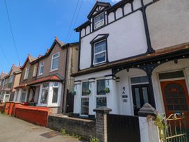A row of terraced houses with front gardens and hanging flower pots at Yr Angor The Anchor in Llandudno Junction