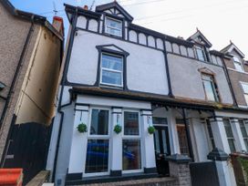 A row of terraced houses with black and white facade and hanging plants at Yr Angor The Anchor in Llandudno Junction