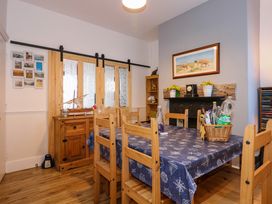 A dining room with a wooden table and chairs a sideboard and a fireplace at Yr Angor The Anchor in Llandudno Junction