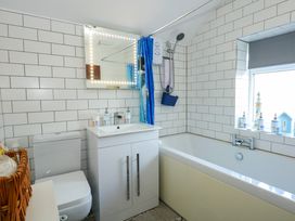 A bathroom with a toilet sink cabinet bathtub and a window at Yr Angor The Anchor in Llandudno Junction