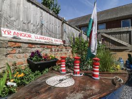 A garden with plants, lanterns, and a sign at Yr Angor Llandudno Junction