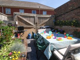 A garden with a table set for dining at Yr Angor (The Anchor) Llandudno Junction