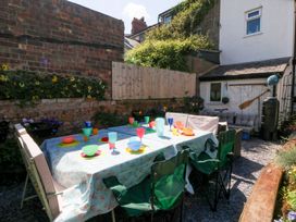 A garden with a table set for dining at Yr Angor (The Anchor) Llandudno Junction