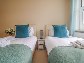 A bedroom with two beds and a flower arrangement at Whitewater Seaview in Newquay