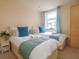 A bedroom with two single beds and a window at Whitewater Seaview in Newquay