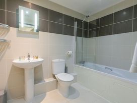 A bathroom with a bath, sink, and toilet at Whitewater Seaview in Newquay