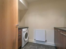 A laundry room with a washing machine and cabinets at Whitewater Seaview in Newquay