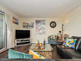 A living room with a television and seating area at Whitewater Seaview in Newquay