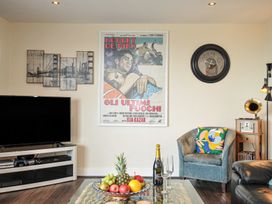 A living room with a television and a fruit bowl at Whitewater Seaview in Newquay