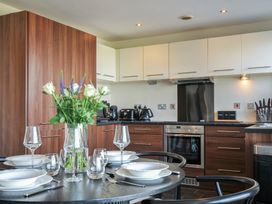 A kitchen with a dining table set and flowers at Whitewater Seaview in Newquay