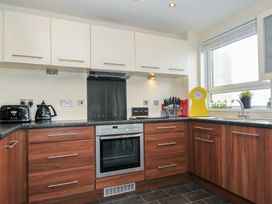 A kitchen with appliances and storage cabinets at Whitewater Seaview in Newquay
