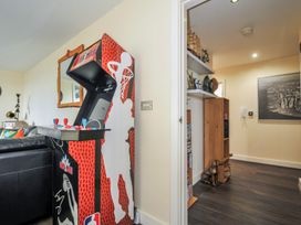 A living room with an arcade machine and shelf at Whitewater Seaview in Newquay