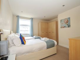 A bedroom with two beds and a wardrobe at Whitewater Seaview in Newquay