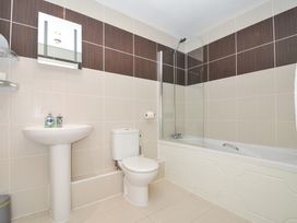 A bathroom with a bath, toilet and sink at Whitewater Seaview in Newquay