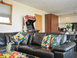A living room with a sofa and arcade machine at Whitewater Seaview in Newquay