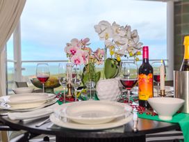A dining table set with plates and wine glasses at Whitewater Seaview in Newquay