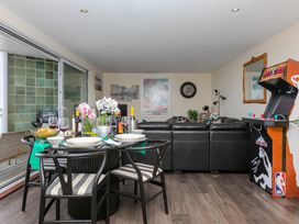 A living room with a dining table and arcade machine at Whitewater Seaview in Newquay