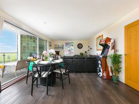 A living room with a dining table and arcade machine at Whitewater Seaview in Newquay