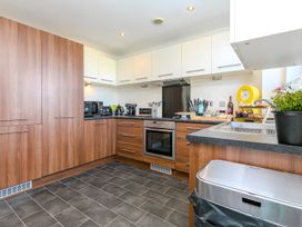A kitchen with cabinets, oven, and appliances at Whitewater Seaview in Newquay