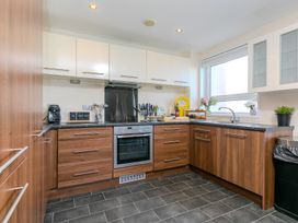 A kitchen with appliances and utensils at Whitewater Seaview in Newquay