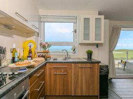 A kitchen with a window view and food items at Whitewater Seaview in Newquay