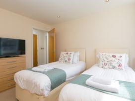 A bedroom with twin beds and a television at Whitewater Seaview in Newquay
