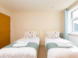 A bedroom with twin beds and a lamp at Whitewater Seaview in Newquay
