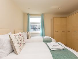 A bedroom with two beds and a wardrobe at Whitewater Seaview in Newquay