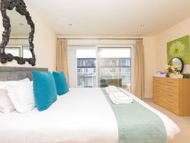 A bedroom with a bed and a dresser at Whitewater Seaview in Newquay