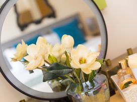 A decorative arrangement with flowers and a mirror at Whitewater Seaview in Newquay