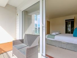 A bedroom with a bed and a balcony at Whitewater Seaview in Newquay